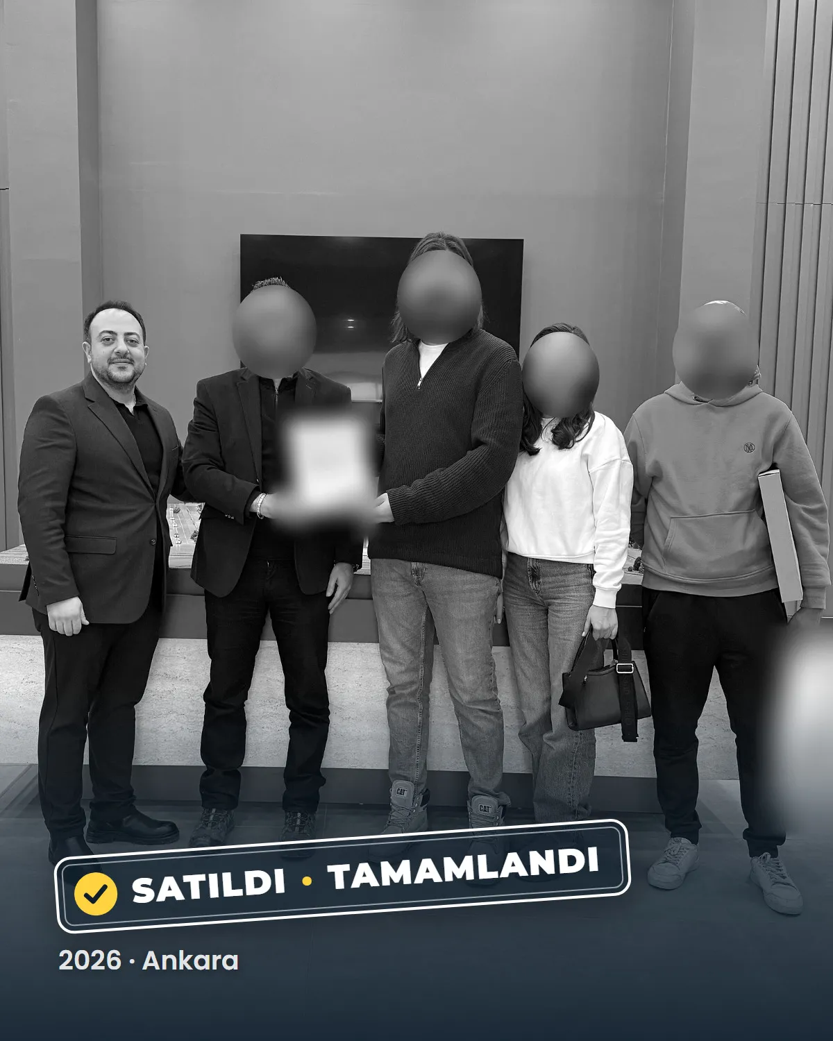 Ankara'da tamamlanan bir konut satışının teslim anı; danışman Sercan Deniz müşterileriyle birlikte. Müşterilerin yüzleri gizlenmiştir. 2026.
